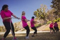 Group of women playing tug of war during obstacle course training Royalty Free Stock Photo