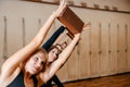 Group of women practicing yoga stretching using wooden blocks, exercise for spine and shoulders flexibility Royalty Free Stock Photo