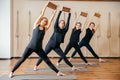 Group of women practicing yoga stretching using wooden blocks, exercise for spine and shoulders flexibility Royalty Free Stock Photo