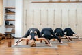 Group of women practicing yoga stretching using wooden blocks, exercise for spine and shoulders flexibility Royalty Free Stock Photo