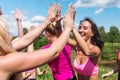 Group of women runners celebrating success and giving five.