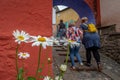 A group of 3 women seen from behind with white and yellow daisies, Portmeirion, North Wales