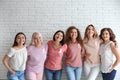 Group of women with silk ribbons near brick wall