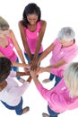 Group of women wearing pink and ribbons for breast cancer putting hands together