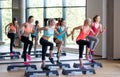 Group of women working out with steppers in gym