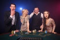 Group of a stylish rich friends are playing poker at casino. Royalty Free Stock Photo