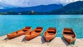 Bled - Group of wooden boats with scenic view of St Mary Church on island of Lake Bled