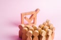 A group of wooden figures of people surround and look at a tick in the box. Voters take part in elections. Voting, referendum, soc