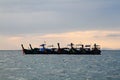 Group of wooden long tail boat floating on sea with raining cloud background. Transportation and Nature Royalty Free Stock Photo