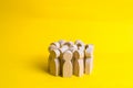 Group of wooden people figurines on a yellow background. Crowd, meeting, social activity. Society, social group. Herd instinct, ma Royalty Free Stock Photo