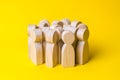 Group of wooden people figurines on a yellow background. Crowd, Royalty Free Stock Photo