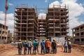 group of workers, building new section of hospital, with scaffolding in the background
