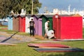 A group of workers - carpenters building plywood cabins with battery drills outdoors on a grass in Heraklion, Greece