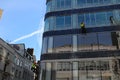 A group of workers cleaning washing windows on high rise building.