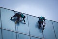 Group of workers cleaning windows service on high rise building