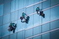 Group of workers cleaning windows service on high rise building