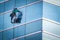 Group of workers cleaning windows service on high rise building