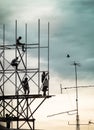 Group of workers are climbing poles to install billboards