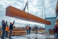 Men working together to lift a massive wooden beam at a construction site. Generative AI Royalty Free Stock Photo