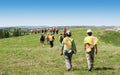 Group of workers in hardhats walking and inspecting grass field