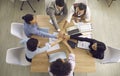 Top view of team of happy people joining hands in business meeting around office table Royalty Free Stock Photo