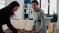 Group of workmates playing game on foosball table Royalty Free Stock Photo