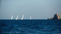 Group yacht boats with white sails near the rocks in the Aegean sea. Royalty Free Stock Photo