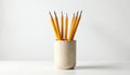 Group of yellow pencils arranged in dotted pattern container atop white surface. Simple composition. Pencils sharpened. Neutral Royalty Free Stock Photo