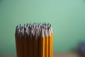 Group of yellow pencils with green background Royalty Free Stock Photo