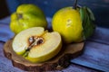 Group of Yellow Ripe Quinces With Leaves On Wooden Background.