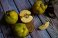 Group of Yellow Ripe Quinces With Leaves On Wooden Background.