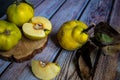 Group of Yellow Ripe Quinces With Leaves On Wooden Background.