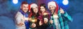 A group of young adult cheerful friends at a party wearing santa hats and tinsel with sparklers in their hands Royalty Free Stock Photo