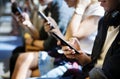 Group of young adult friends using smartphones in the subway Royalty Free Stock Photo