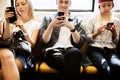 Group of young adult friends using smartphones in the subway Royalty Free Stock Photo