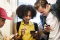 Group of young adult friends using smartphones in the subway Royalty Free Stock Photo