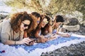 Group of young adult women use modern phones together having fun and laughing a lot - happy females people enjoying technology and