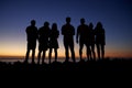 Group of young adults admiring sunset by the seaside Royalty Free Stock Photo