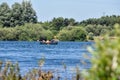 A group of young adults kayaking on a lake in summer