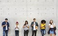 Group of young adults outdoors using smartphones together and ch Royalty Free Stock Photo