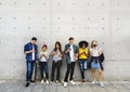 Group of young adults outdoors using smartphones together and ch