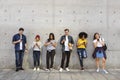 Group of young adults outdoors using smartphones together and ch Royalty Free Stock Photo