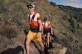 Group of young adults training and running together through trails on the hillside outdoors in nature. Royalty Free Stock Photo