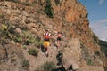 Group of young adults training and running together through trails on the hillside outdoors in nature. Royalty Free Stock Photo