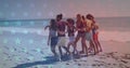 Group of young adults walking together on a beach Royalty Free Stock Photo
