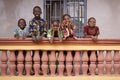 Group of Young African Children Linung Up On Their City Home Balcony Smiling to Bypassers