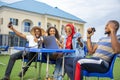 Group of young Africans sitting together celebrating the success of their online startup business