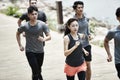 Group of young asian adults running outdoors Royalty Free Stock Photo