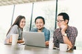 Group of young Asian business colleagues or college students using laptop in team casual discussion Royalty Free Stock Photo