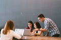 Group of young Asian business colleagues in team casual discussion, startup project business meeting or happy teamwork brainstorm